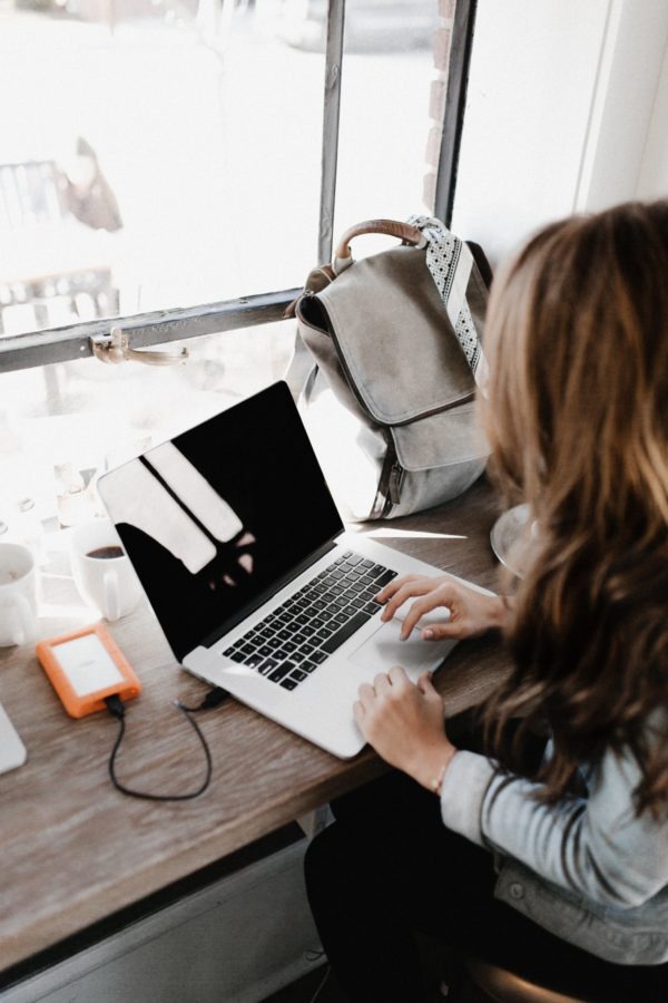Femme devant son ordinateur avec son café